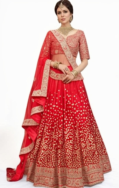 Stunning Red Lehenga Choli with Gold Embroidery for a Traditional Bridal Look. A woman wearing a vibrant red lehenga choli set with intricate gold embroidery. The lehenga features a flared design with detailed patterns, paired with a matching blouse and a flowing dupatta draped over one shoulder. She accessorizes with gold jewelry, including a necklace, earrings, bangles, and a maang tikka, exuding a traditional and elegant bridal look.